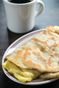 The Little Goat Diner’s Naamelette—an egg enrobed in Indian naan bread—showcases the increasing use of ethnic ingredients in American dishes.