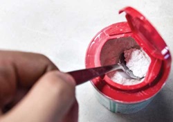 Scooping powder from a container.