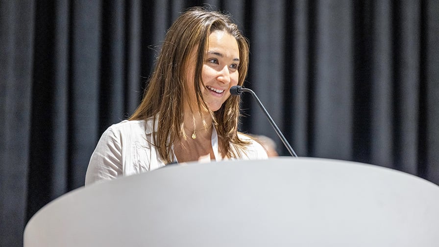 A student speaking at a podium on stage.