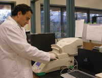 Research scientist loads a sample into the iQ5™ real-time PCR detection system.