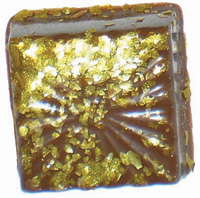 A mica-based pigment added to ground edible film can give a gold luster to this block of chocolate. This development, one of several emerging ingredients, may provide value to the food formulator.