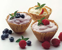 New concepts and strategies are helping to upscale traditional yogurt and broaden its appeal in the marketplace. Borrowing an ice cream innovation, these yogurt products are served in a waffl e-cone-style cup with fruit toppings.