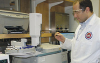 FDA chemist Pierluigi Delmonte checks a sample for analysis in an Agilent Technologies gas chromatograph.