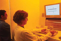 Sensory panel members evaluate the flavor of chicken. The red lighting gives all samples the same color.