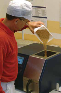 Technician adds a wheat sample to Foss’s Infratec 1241 Grain Analyzer. The instrument includes ready-to-use calibrations for protein, moisture, starch, and oil in corn, soybeans, and rice and requires no sample preparation.