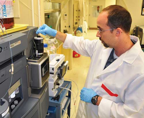 A scientist optimizes a mass spectrometer for sample analysis.