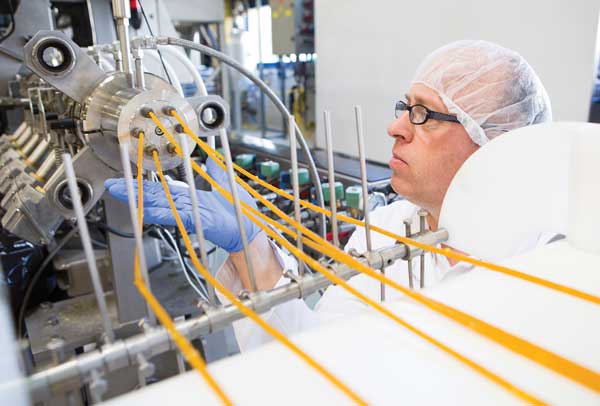 A technician conducts a test on extruded corn flakes. 