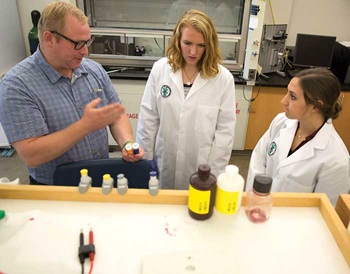 Jason Kenealey explains a concept to BYU students Deb Hutchins (center) and Hannah Allen (right).
