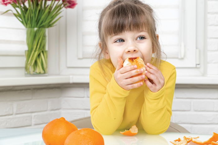 girl eating orange