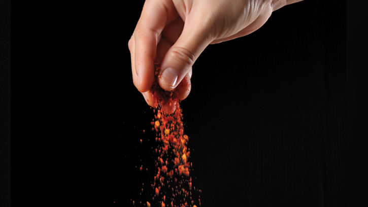 Hand sprinkling cayenne pepper