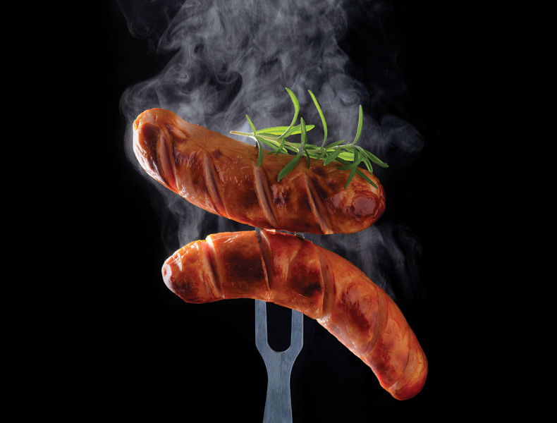 grilled sausage with rosemary and steam on the fork
