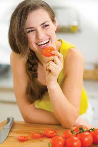 Woman eating tomato