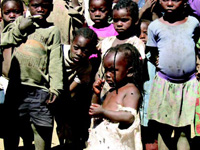 Children wait for the preparation of a meal of fortified maize meal in Lusaka, Zambia.