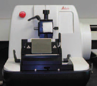 Fig. 2—50-mm × 50-mm block of a spool of fibers, mounted on a microtome chuck. The mounting is eccentric because the standard microtome blade is 110 mm long. After approximately 10,000 sections are cut, the blade can be moved to the viewer’s right, and the other half of the blade can be used to cut an additional 10,000 sections.