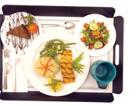 Patients can order enticing meals (top photo) from a hotel-style room service menu at Memorial Sloan-Kettering Cancer Center in Manhattan. The standard hospital tray (bottom photo) is not quite so alluring.