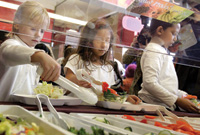 Students choose items from a salad bar in the new lunch program called “Cool Foods,” part of the Healthy Schools Campaign, at Chicago’s Nettelhorst Elementary School.