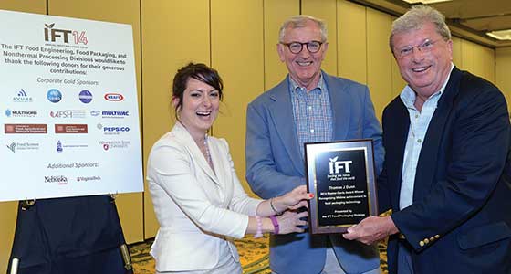 Valentina Trinetta and Peter Salmon present the Riester-Davis Award to Thomas Dunn (center).