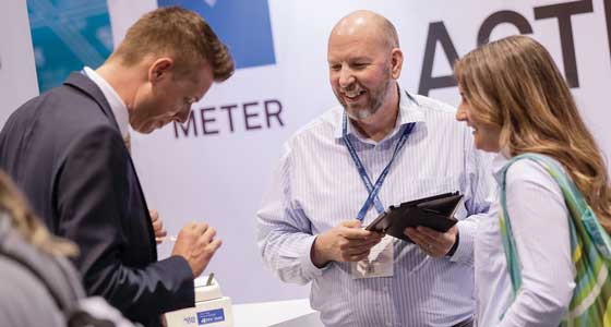 An IFT18 attendee presents his badge for scanning after hearing about METER’s water activity instruments.