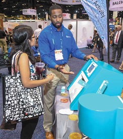 A representative for Neutec Group demonstrates how to use the company’s water activity meter.