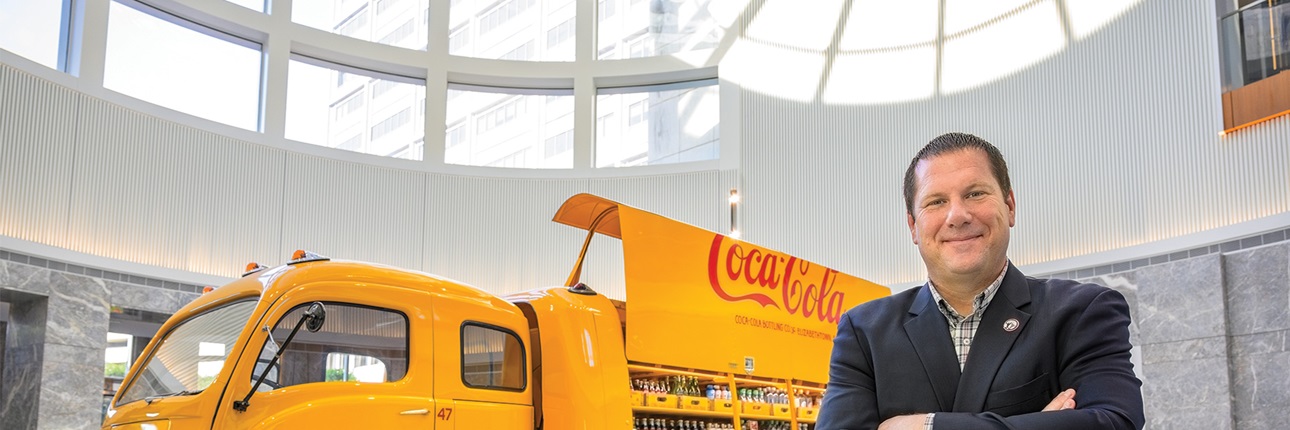 Jason Richardson, Coca-Cola’s global director, standing in front of yellow Coca-Cola truck