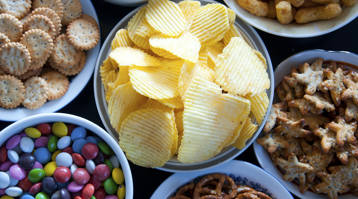 Bowls of junk food such as potato chips, crackers, candy, pretzels, and puffs