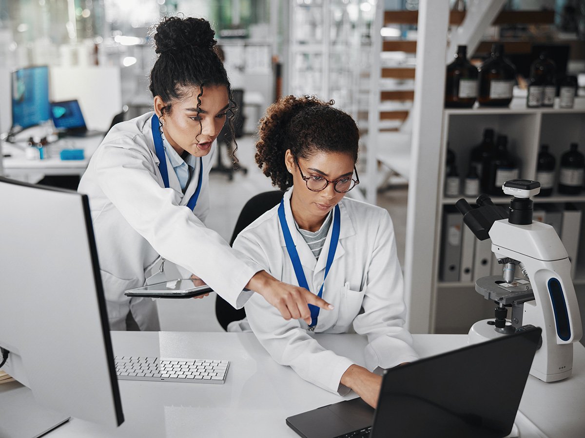 Two female food scientists working in a lab looking at a computer