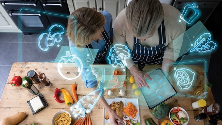 Senior couple cooking at home and using technology to do a calorie count