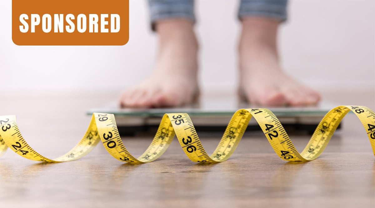 Two feet pictured on a scale with a measuring tape in the foreground. Sponsored tag in upper left corner.