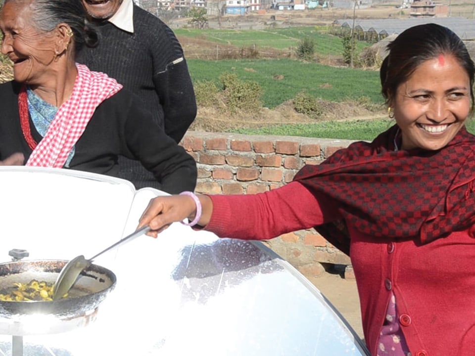 Cooking with a parabolic solar cooker in Nepal