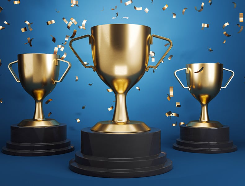 Three golden trophies with falling confetti