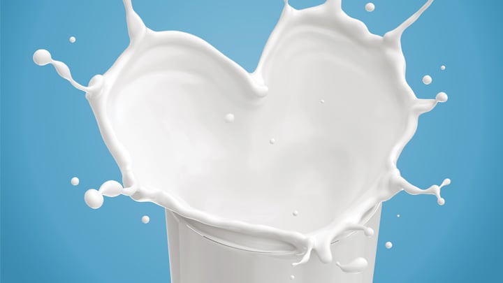 Heart shaped milk splashed in a glass.