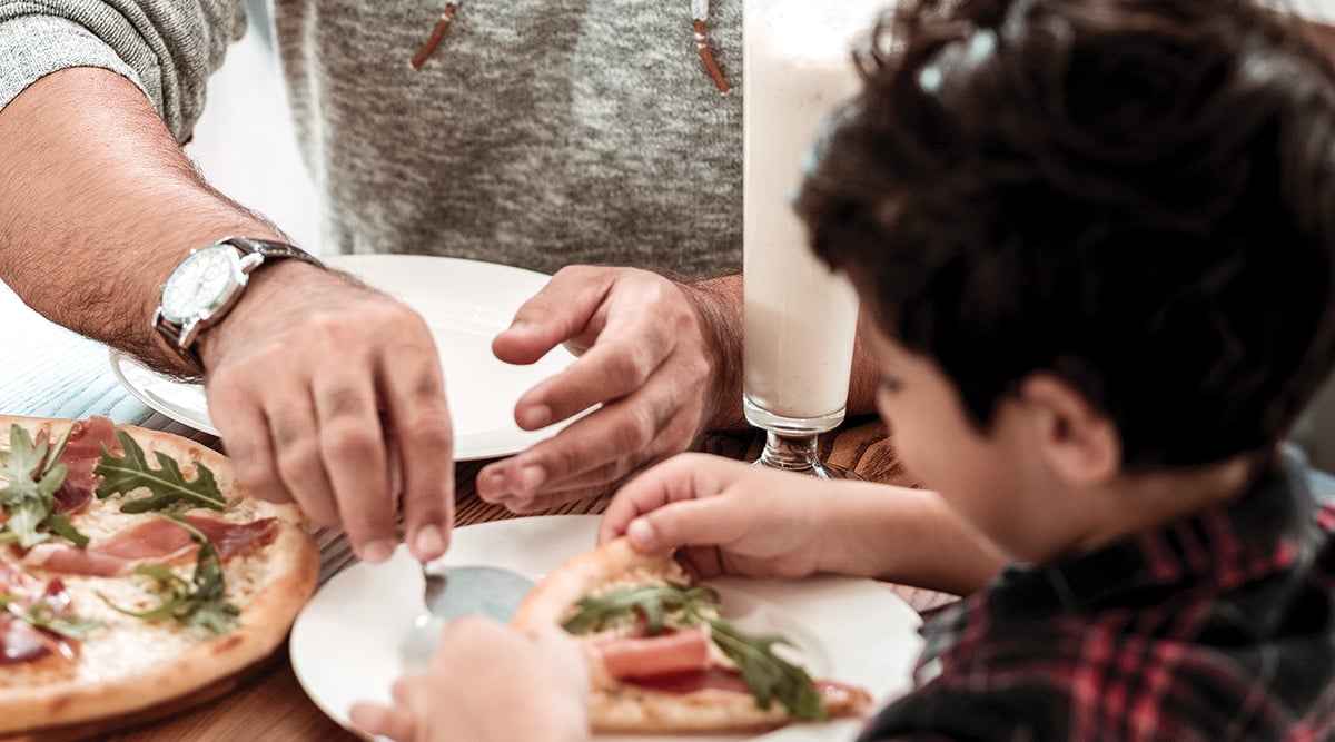 Father and son sharing pizza.