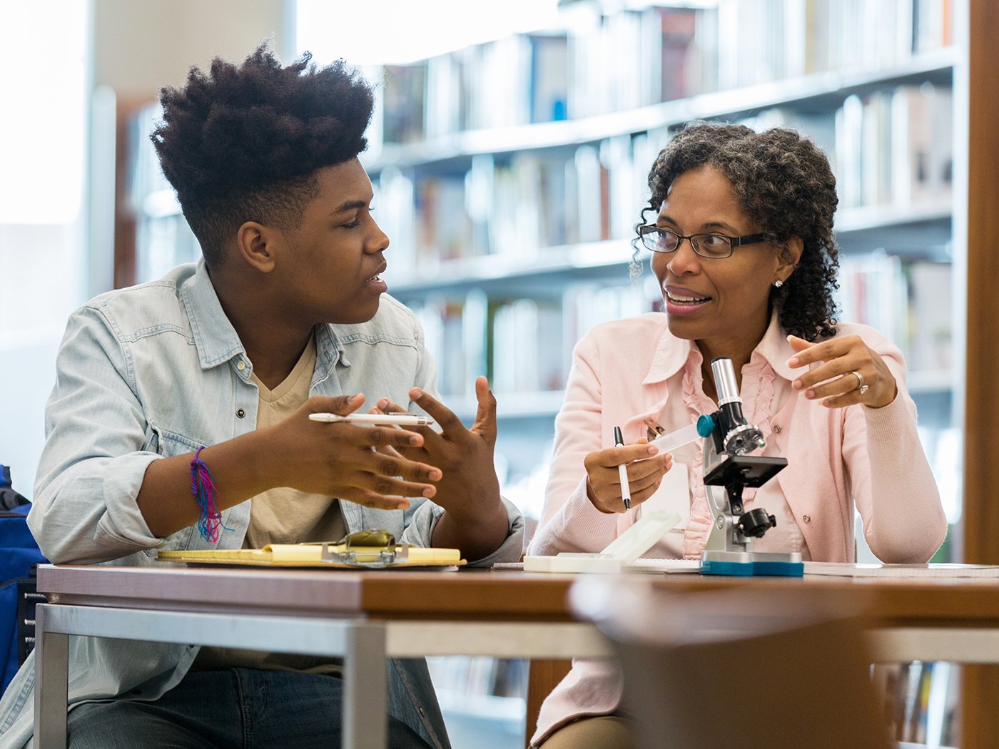 High school tutor helps teen boy with science experiment
