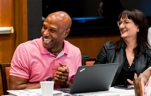 Man Smiling next to laptop