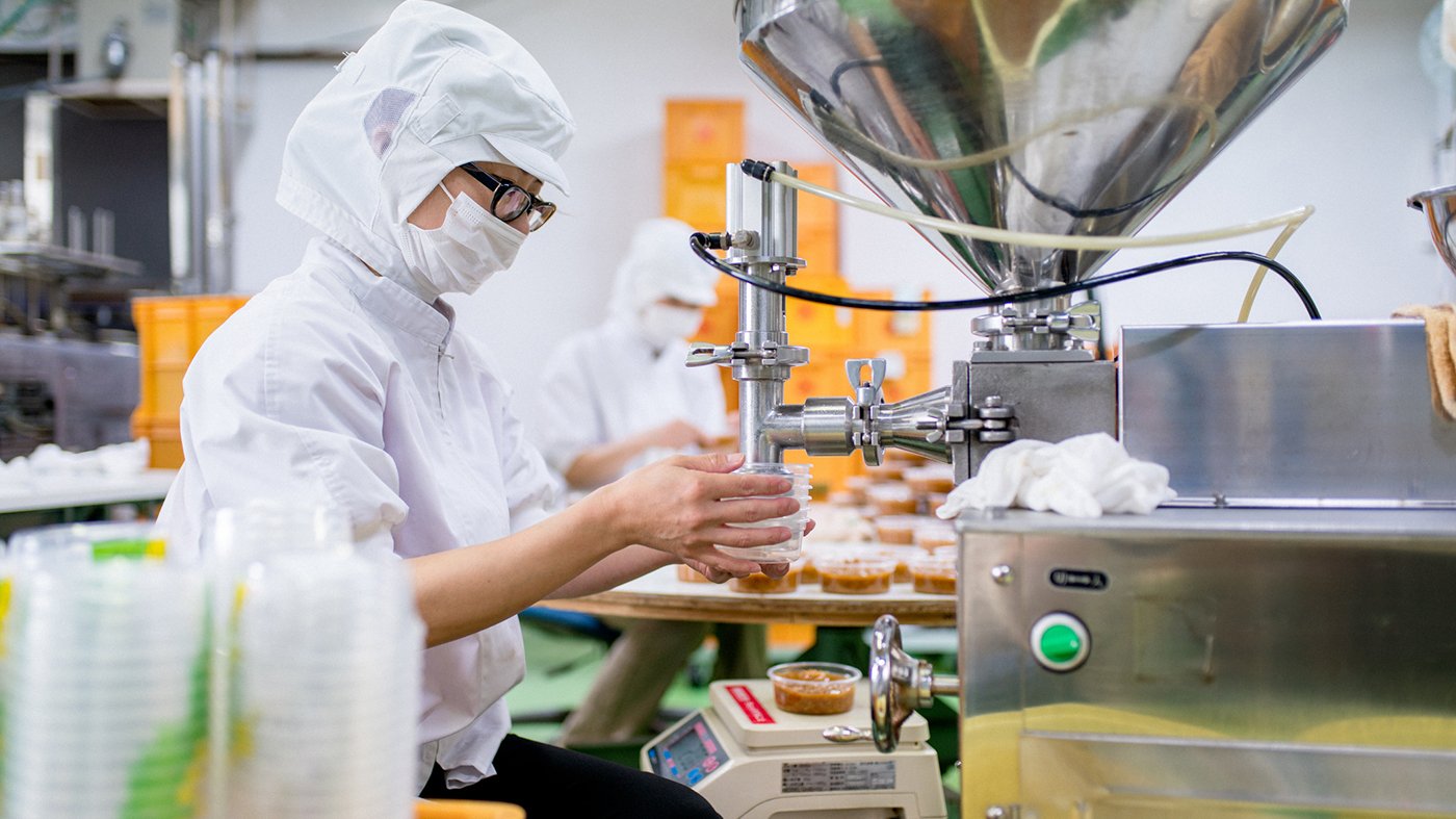 Workers in a food processing factory packaging food