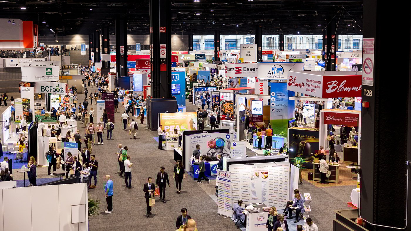 Overhead view of a busy expo hall with exhibitor booths and attendees at IFT FIRST.