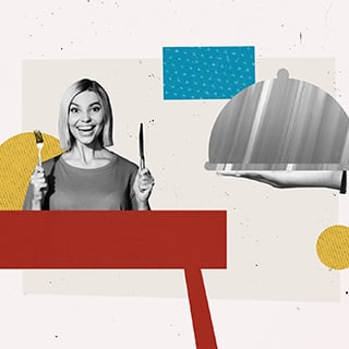 Excited woman holding a fork and knife ready to be served a plate of food with a cover on top.