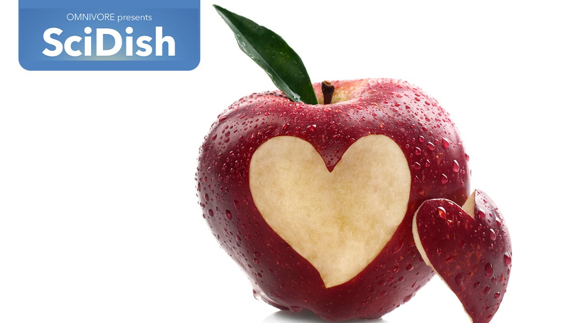 A red apple with a heart cut out of it.