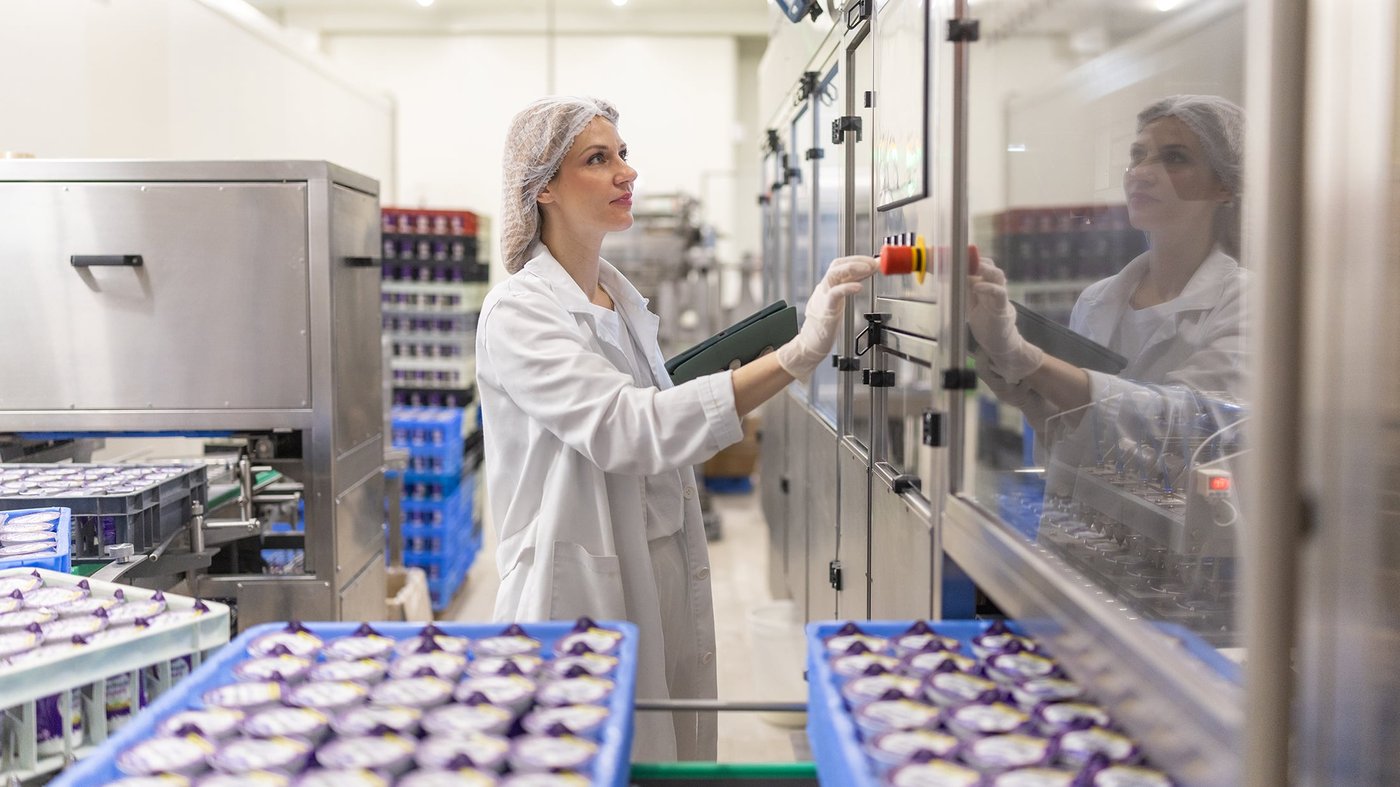 Portrait of woman operating machines at food factory
