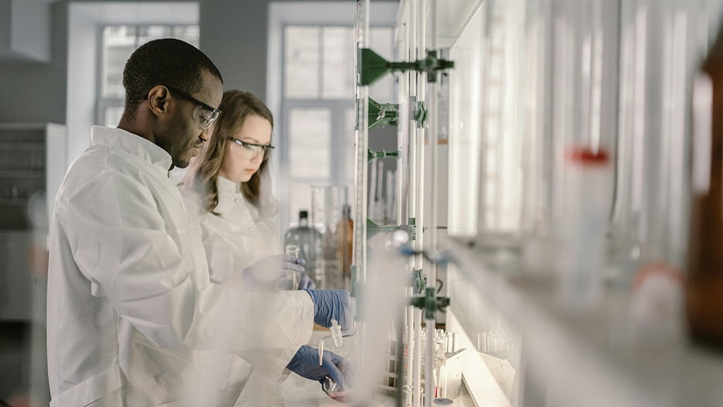 Food scientists conducting lab experiments with glassware, representing innovation, product development, and food technology trends.