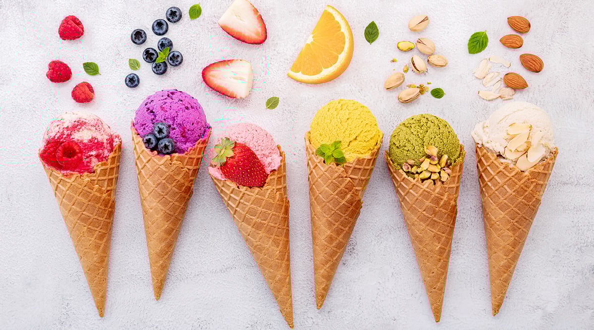 Colorful ice cream cones with fruits and nuts toppings.