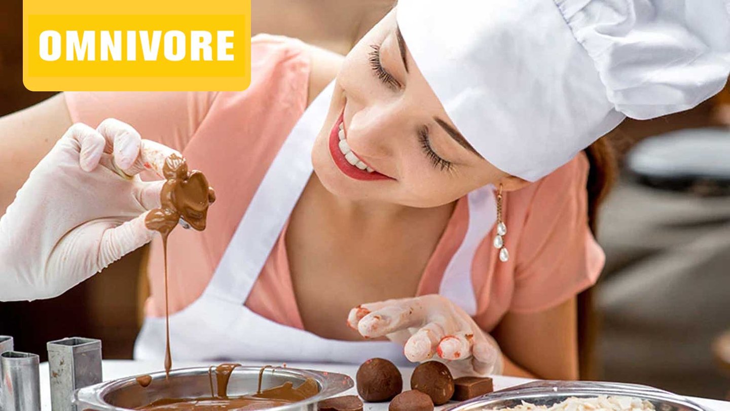 Omnivore Podcast Episode 10 a smiling baker dipping a piece of dough in chocolate