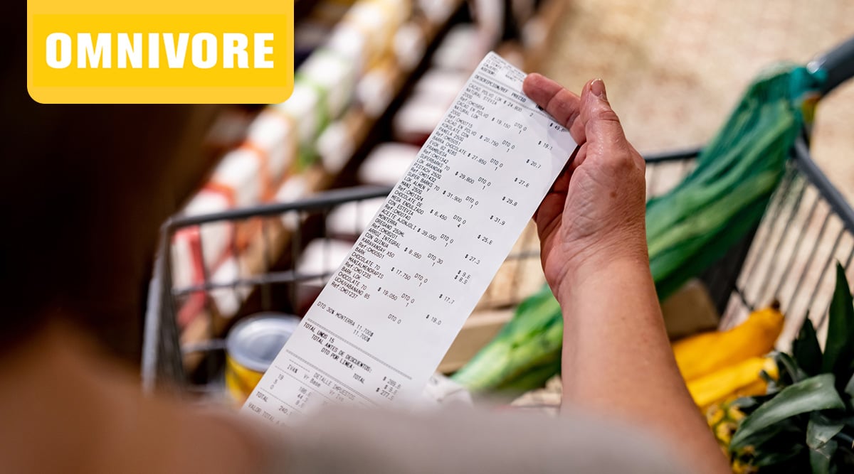 Person at a grocery store looking at their receipt.