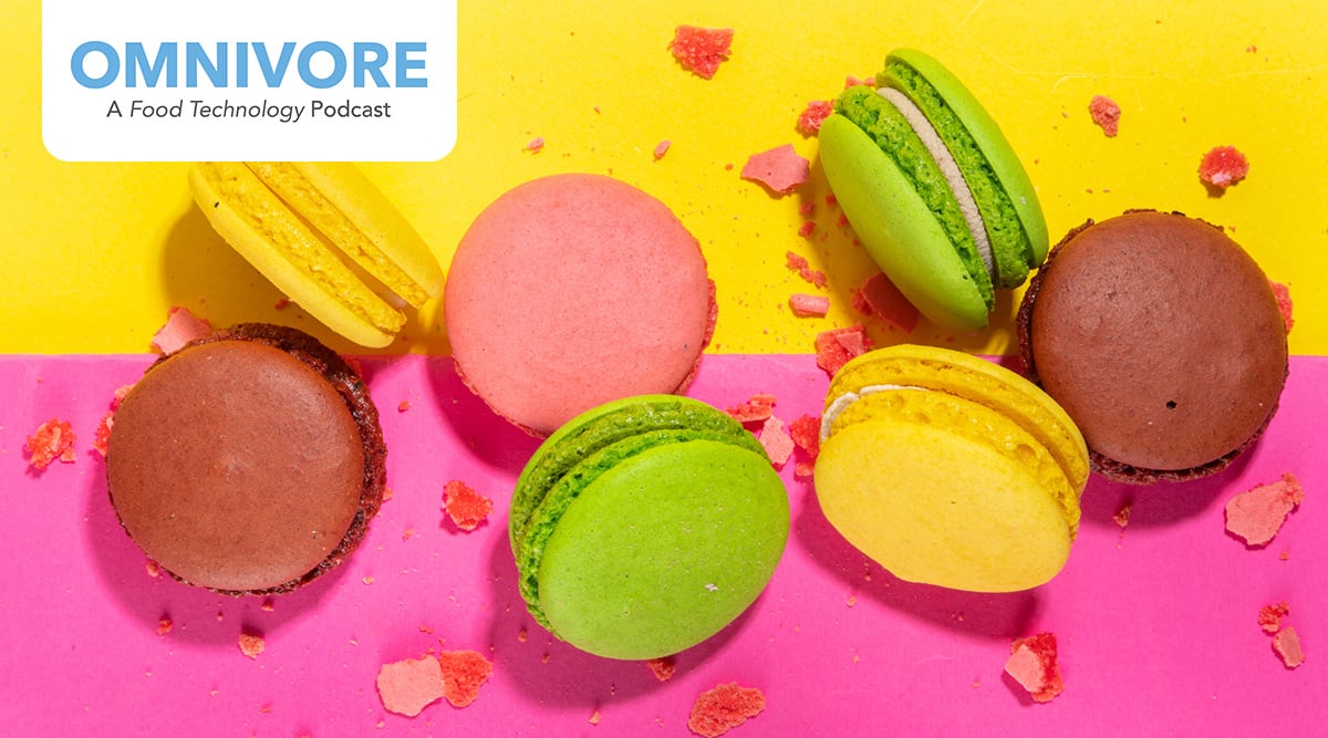 Colorful macarons against a pink and yellow background.