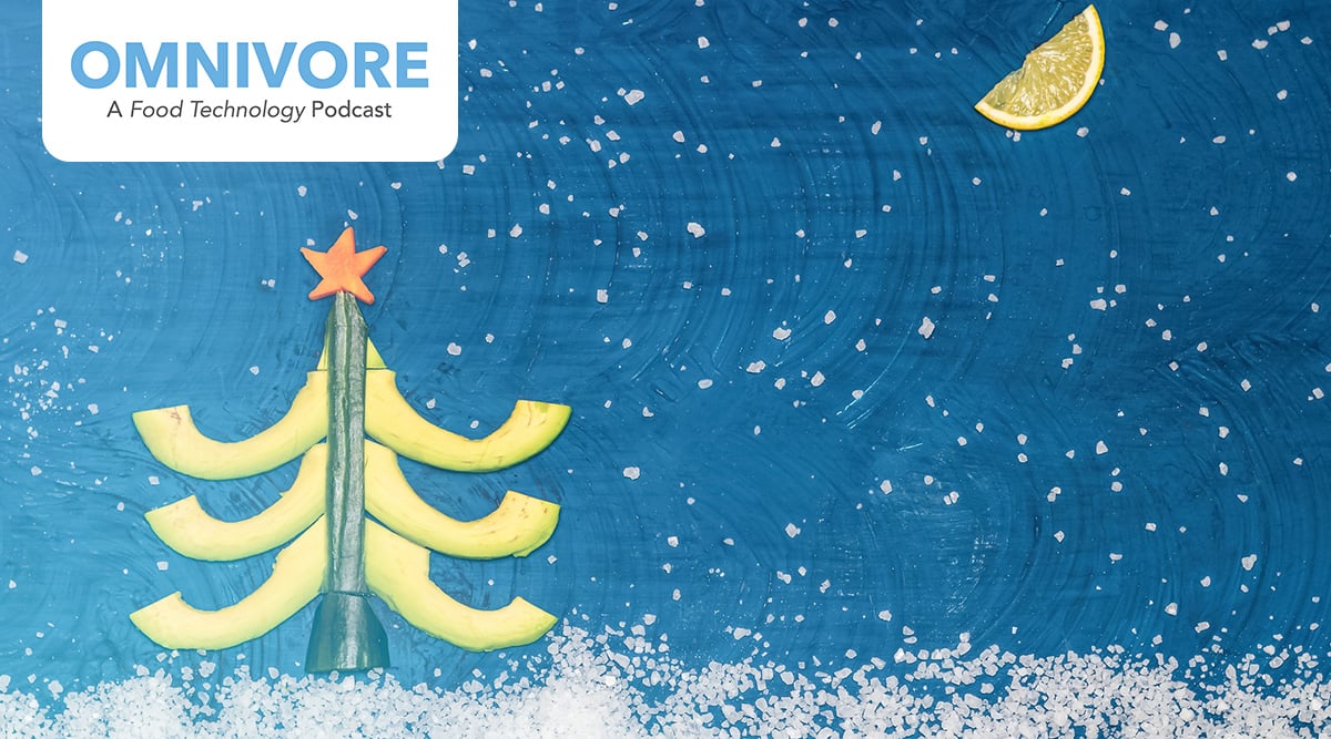 A Christmas tree against a blue snowy backdrop and a lemon slice in the sky