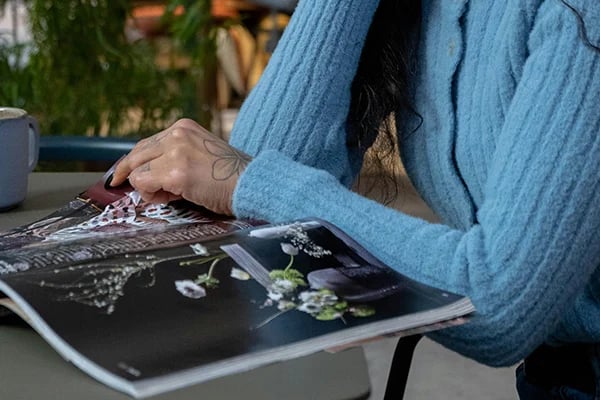 Person seated flipping through a magazine.