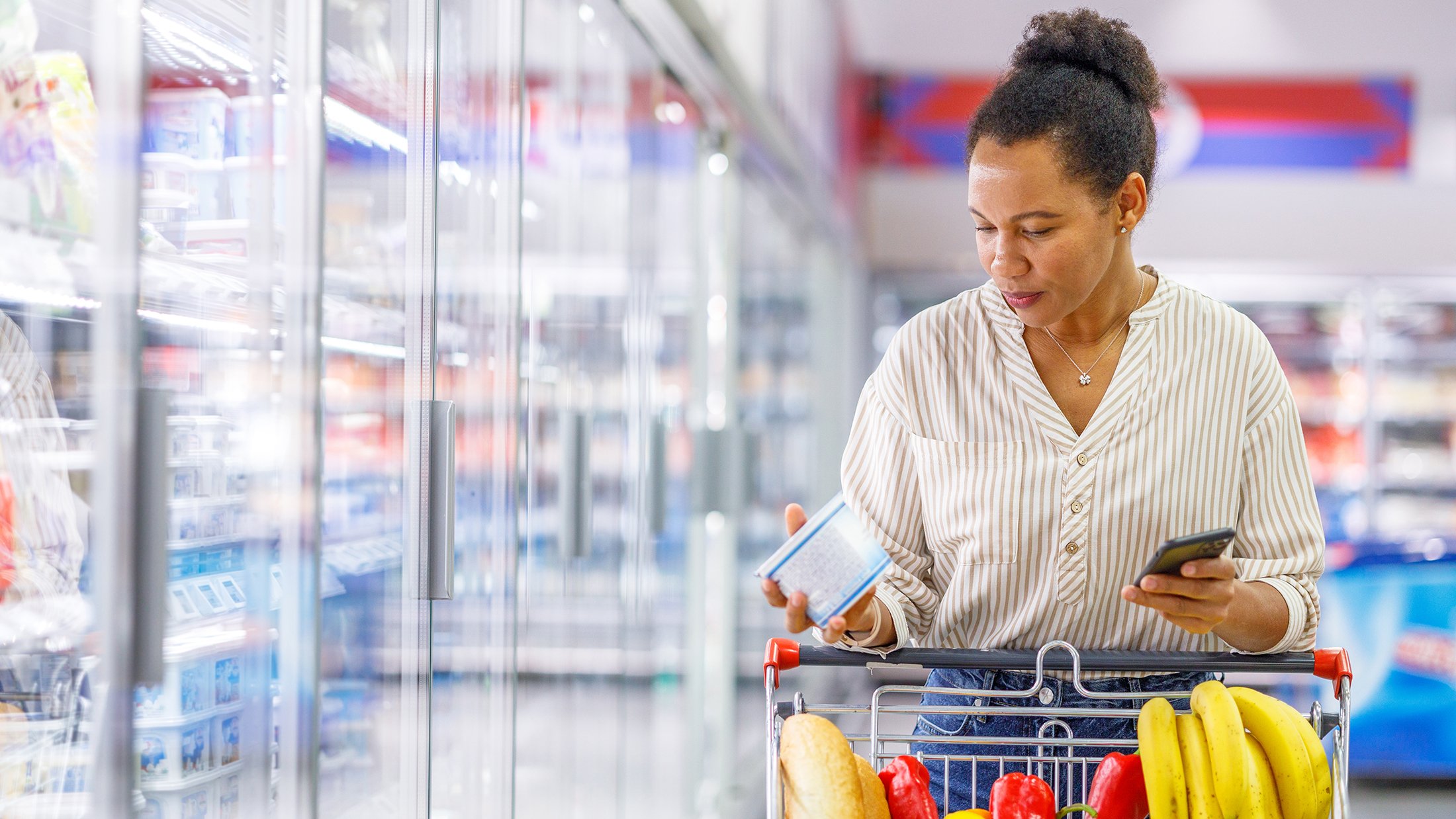 Woman comparing food product in grocery store