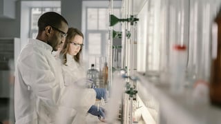 Food scientists conducting lab experiments with glassware, representing innovation, product development, and food technology trends.
