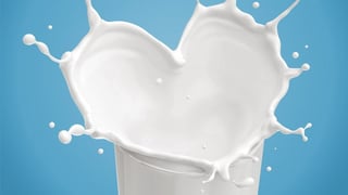 Heart shaped milk splashed in a glass.