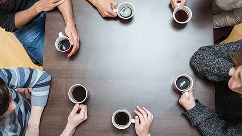 People gathered around a table with coffee